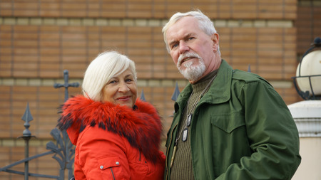 Portrait of a loving elderly couple on a background of autumn cityscapeの写真素材