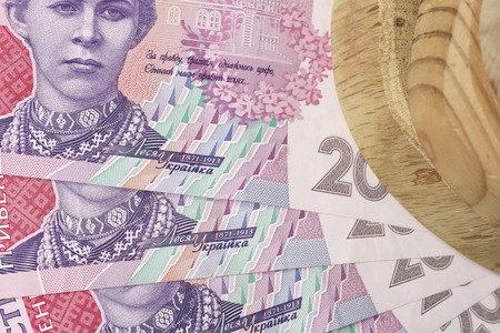 Ukrainian paper banknotes in denomination of two hundred hryvnias with processed wooden blank close-up macro photo backgroundの写真素材