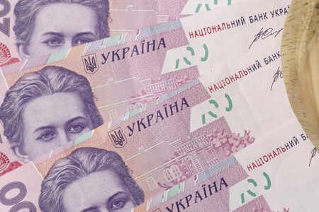 Ukrainian paper banknotes in denomination of two hundred hryvnias with processed wooden blank close-up macro photo backgroundの写真素材