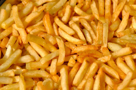 French fries potatoes cooked in warm oil on a plate close up