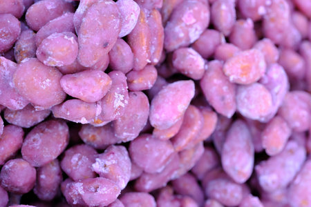 Roasted kernels of nuts, covered with a crispy shell of different ingredients in a close-up, macro