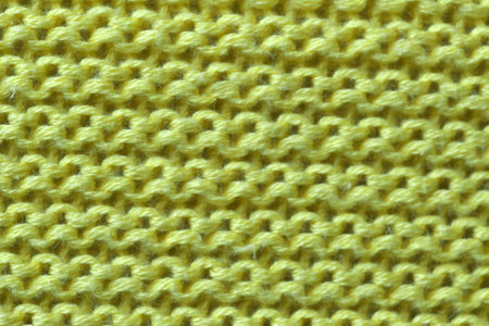Knitted woolen fabric of a machine large knitting close-up, an element of a woman's dress macro...