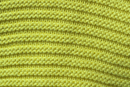 Knitted woolen fabric of a machine large knitting close-up, an element of a woman's dress macro...