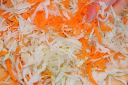 Shredder cabbage for pickling with carrots and spices in a glass jar in a city apartment, close-upの写真素材