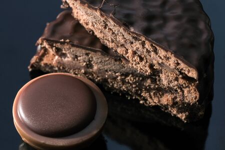 Chocolate candies with nut filling close-up on a dark mirror background macro photoの写真素材