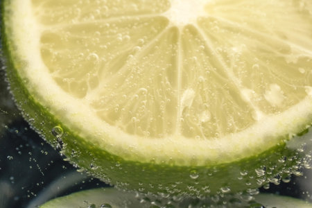 Slices of lime in a glass of soda water close-up macro photography product background