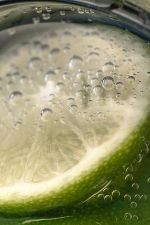 Slices of lime in a glass of soda water close-up macro photography product background