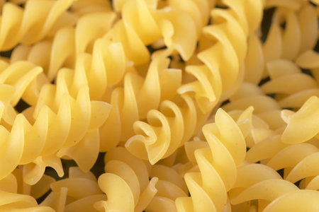 Small pasta made from premium wheat flour and eggs fall on a dark table surface close-up grocery background macro photographyの写真素材
