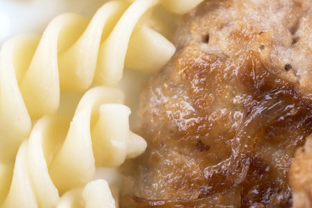 Tasty fresh hot meat cutlet from a mix of beef, pork and chicken fried with onions close-up with...