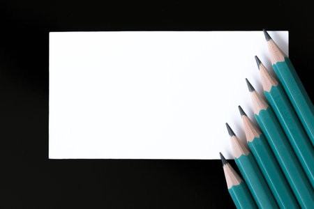 Six simple pencils of green color close-up on a black background macro photography