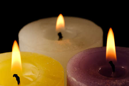 Extinguished thick commemorative yellow candle on a black background close-up macro photographyの写真素材