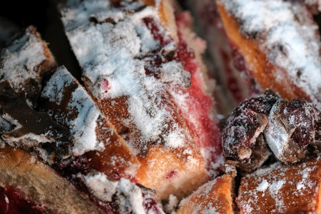 Cherry pie with chocolate icing sprinkled with powdered sugar close-up macro photographyの写真素材