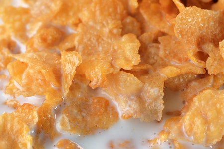 Cornflakes with sugar icing with milk for breakfast close-up macro photographyの写真素材