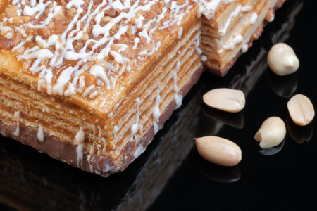 Wafer caramel cake with peanuts close-up on a black background macro photography