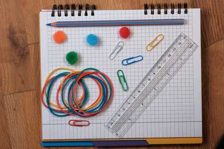 On an open tear-off notebook for notes, sheets of paper in a box, lies a switched off tablet with a...