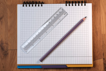 On an open tear-off notebook for notes, sheets of paper in a box, lies a switched off tablet with a black screen on a wooden background close-upの写真素材