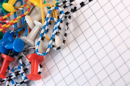 Symbolic illustration of office, scientific work and education open notebook with detachable sheets with paper clips and buttons macro photographyの写真素材