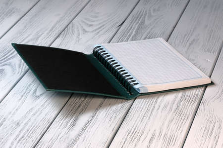 Layout composition with loose-leaf notebook on white wooden background with candleの写真素材