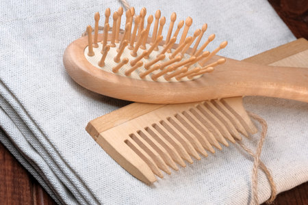 Wooden massage combs on a linen napkin close up on dark wooden background hair care tools