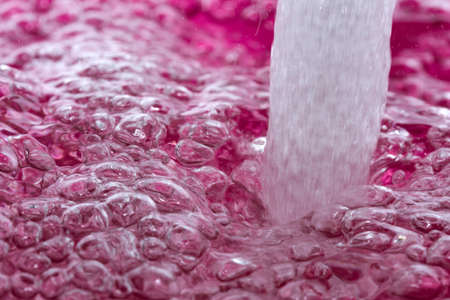 Abstract artistic textured pink background with air bubbles on water surface close-upの写真素材
