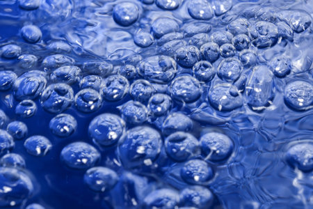 Abstract artistic textured blue background with air bubbles on water surface close-up