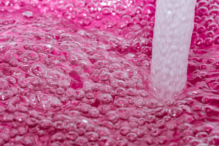 Abstract artistic textured pink background with air bubbles and falling jet on water surface...