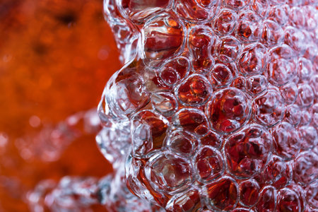 Abstract macro photography water in a powerful stream fills a red vase with the formation of air...