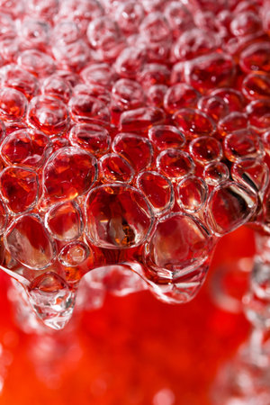 Abstract macro photography water in a powerful stream fills a red vase with the formation of air...