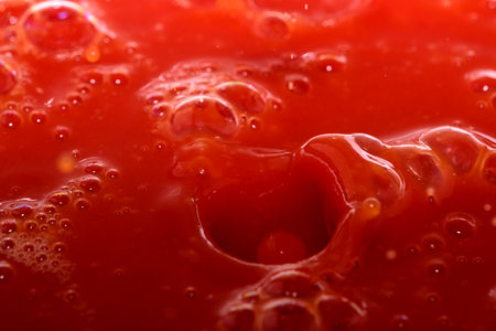 Red grocery background of tomato juice with splashes and bubbles close-upの写真素材