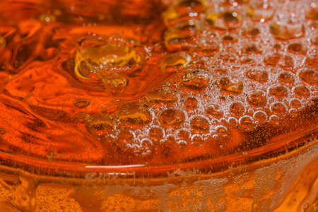 Drops and bubbles of light beer in a glass bullet shot close-up macro photographyの写真素材