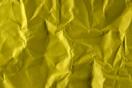 Paper textured background from crumpled yellow paper close-up macro photography high detail