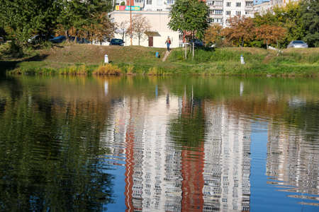 Cityscape with a small lake on an autumn warm sunny dayの写真素材