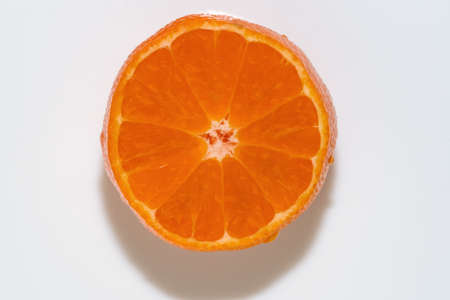 Slice of orange ripe sweet tangerine on white background close-upの写真素材