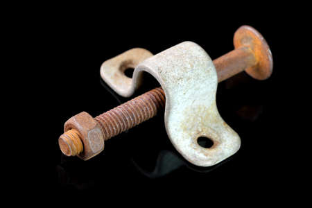 Old used bolt and nut on black mirror background close-up macro photographyの写真素材