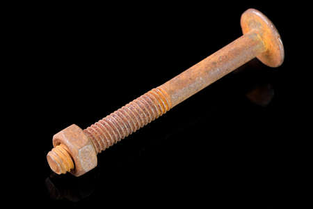 Old used bolt and nut on black mirror background close-up macro photographyの写真素材