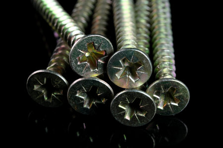 Long screws for a screwdriver on a black background close-up macro photography