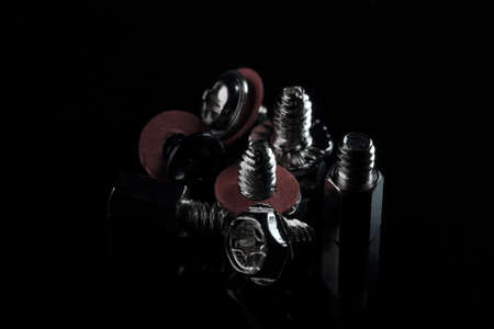 Bolts, screws, washers on a black background for the assembly and installation of computer equipment close-up macro photographyの写真素材