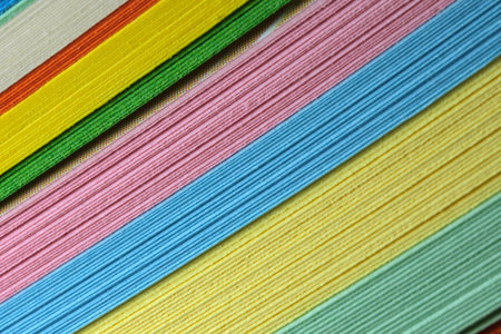 Bundle of multicolored stationery, paper background close-up