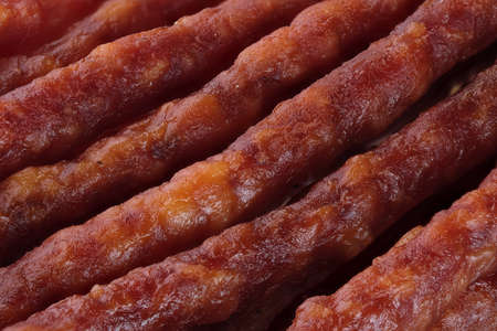 Dry smoked sausage thin sticks full screen close up food backgroundの写真素材