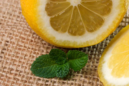 Cut lemon close-up on a table with a napkin next to fragrant mint leavesの写真素材