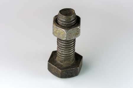 Old bolt and nut on a white mirror background close-up macro photographyの写真素材