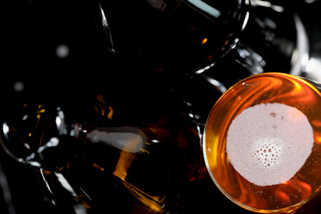 Fresh live light bottled beer on a black background macro photographyの写真素材