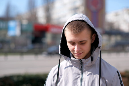Portrait of a young handsome guy with a short haircut on the street of a spring city close-up on a...