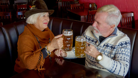Cute couple elderly man and woman in a beer bar relaxing with a glass of beerの写真素材