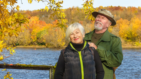 Portrait of an elderly gray-haired couple, a man in militarized khaki clothes, a woman in a black...
