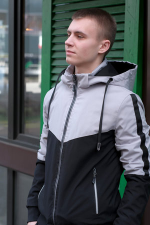 Urban street portrait of a young handsome guy in stylish youth sportswear