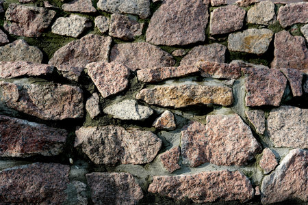 Rough surfaces of multi-colored stones form a captivating wall pattern.の写真素材