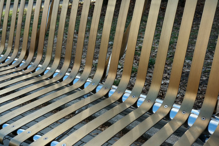 Golden stripes of a modern bench invite relaxation in a serene park.の写真素材