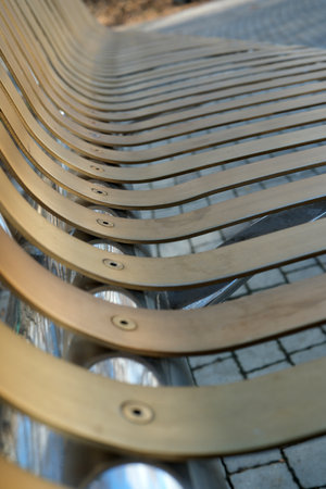 Curving lines of a minimalist bench shimmer under a bright sun, inviting rest.の写真素材