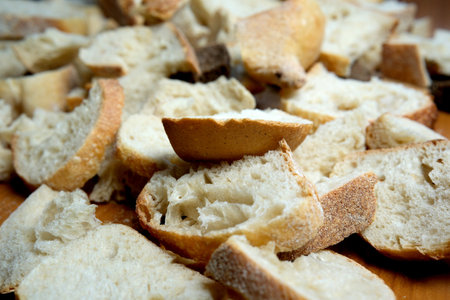 Sliced and torn bread pieces create a rustic display on wood.